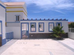 une maison avec un palmier devant dans l'établissement Sol e Mar, à Vila Nova De Cacela