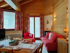 un soggiorno con tavolo e sedie rosse di Chalets Mignon a Limone Piemonte