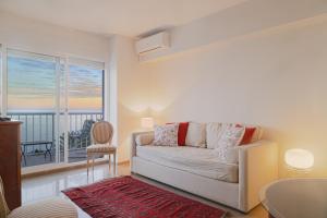 - un salon avec un canapé et une grande fenêtre dans l'établissement Miradores Malagueta Beach, à Malaga