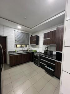 a large kitchen with a sink and a stove at Lovely 3-Bed with a Pool next to Four Point in Lagos