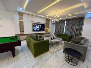 a living room with a pool table and couches at Lovely 3-Bed with a Pool next to Four Point in Lagos