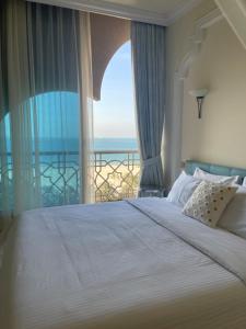 a bedroom with a large bed with a view of the ocean at Private Suites Al Hamra Palace at golf & sea resort in Ras al Khaimah
