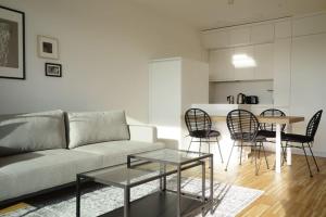 uma sala de estar com um sofá, cadeiras e uma mesa em Apartment with terrace near Metro Station and Spa em Viena