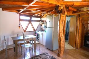 eine Küche und ein Esszimmer mit einem Tisch und einem Kühlschrank in der Unterkunft Hermoso Domo ECOconstruido in San Pedro de Atacama