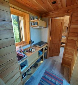 una cucina con lavandino in una casetta minuscola di Glamping Vulcanche a Villa Traful