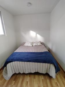 1 dormitorio con 1 cama con manta azul en Departamento Yekamush Ushuaia en Ushuaia