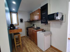 una pequeña cocina con nevera blanca y microondas en Departamento Yekamush Ushuaia en Ushuaia