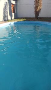 una piscina de agua azul frente a una casa en Casa Grande pileta próximo kempes y aeropuerto Córdoba Capital en Córdoba