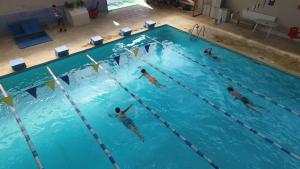 a group of people swimming in a swimming pool at 4 Room Penthouse Terrace W18+W19 in Bucharest