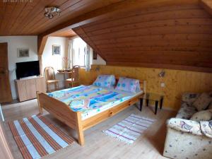 ein Schlafzimmer mit einem großen Bett und einem Sofa in der Unterkunft Ubytování U Potoka in Kunratice