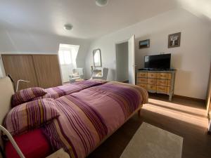 a bedroom with a bed and a dresser and a television at Superbe Villa Face à L'Océan in Plouhinec