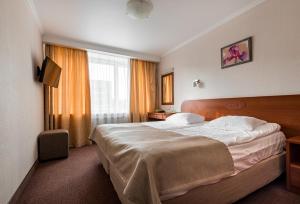 ein Hotelzimmer mit einem großen Bett und einem Fenster in der Unterkunft Sputnik Hotel in Sankt Petersburg