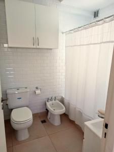 La salle de bains blanche est pourvue de toilettes et d'un lavabo. dans l'établissement Hermoso Departamento en Recoleta muy luminoso, à Buenos Aires