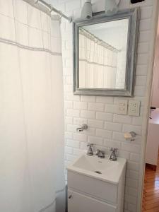 La salle de bains blanche est pourvue d'un lavabo et d'un miroir. dans l'établissement Hermoso Departamento en Recoleta muy luminoso, à Buenos Aires