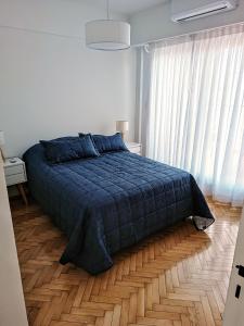 a bedroom with a blue bed and a wooden floor at Hermoso Departamento en Recoleta muy luminoso in Buenos Aires