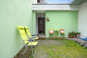 grupa krzeseł siedzących po stronie domu w obiekcie Casa Vacanze il Ginepro w mieście Sinio