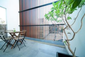 stół i krzesła na balkonie z rośliną w obiekcie 會呼吸的房507-睡虎尾-電梯bnb w mieście Huwei