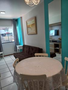 a living room with a table and a couch at Apartamento Balneário Piçarras in Piçarras