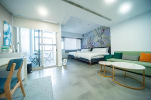 Cette chambre comprend un lit, un canapé et une table. dans l'établissement 會呼吸的房507-睡虎尾-電梯bnb, à Huwei