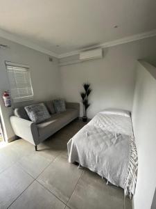 a living room with a bed and a couch at Guest house on Gillian Unit 6 in Ballito