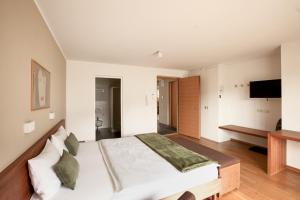 um quarto com uma cama e uma televisão na parede em Residence Panorama em Brunico