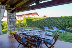 een houten tafel en stoelen op een patio bij Gardaliva - Home & Garden by Garda FeWo in Manerba del Garda