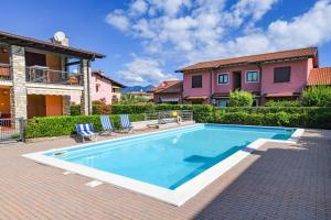a swimming pool in front of a house at Gardaliva - Home & Garden by Garda FeWo in Manerba del Garda