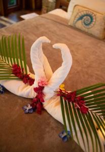 a swan made out of towels on a bed at Ocho Artisan Bungalows in Tamarindo