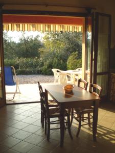 a table and chairs in a room with a patio at Agriturismo Renzano garden apartments in Salò
