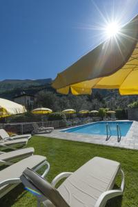 un grupo de sillas y sombrillas junto a una piscina en Hotel Garni Ischia, en Malcesine