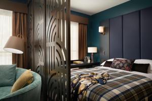 a bedroom with a bed and a couch and a table at The Other House South Kensington in London +84 photos