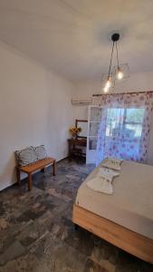 a bedroom with a bed and a bench and a window at Anna Garden Sidari in Sidari