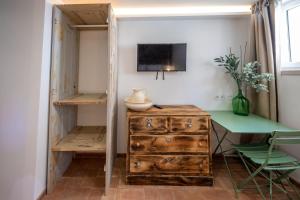 Zimmer mit einem Schreibtisch, einer Holzkommode und einem Tisch in der Unterkunft Villa Galega in Silveira