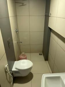 La petite salle de bains est pourvue de toilettes et d'un lavabo. dans l'établissement Select Residency, à Kozhikode