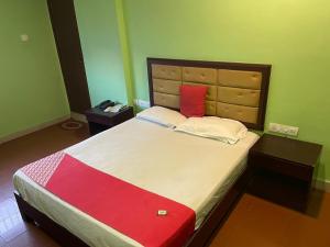 sypialnia z dużym łóżkiem i czerwoną poduszką w obiekcie Select Residency w mieście Kozhikode