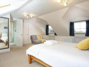 1 dormitorio con 1 cama blanca grande en el ático en The Yellow House, Tideford, UK, en Saint Germans