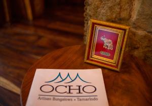 a sign sitting on a table next to a picture at Ocho Artisan Bungalows in Tamarindo