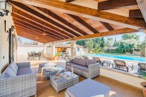 an outdoor patio with couches and a swimming pool at Can Canaves in Pollença