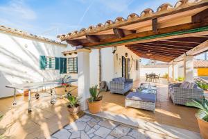 a patio with a table and chairs on a house at Can Canaves in Pollença
