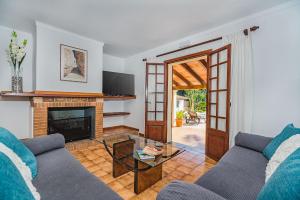 a living room with a couch and a fireplace at Can Canaves in Pollença