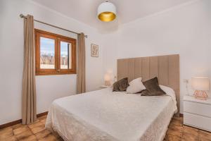 a bedroom with a white bed and a window at Can Canaves in Pollença +22 photos