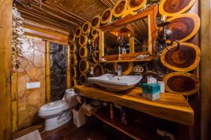 a bathroom with a sink and a toilet and a mirror at Ocho Artisan Bungalows in Tamarindo