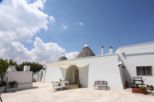 a white building with a table in the courtyard at Borgo Tortorella by IL PUMO DI PUGLIA in Monopoli