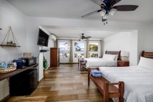 a bedroom with two beds and a table with a fan at Casa Isleña in Rincon