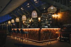 eine Bar mit Barhockern und Kronleuchtern in der Unterkunft Maplewood Cottage, Wynyard Hall in Grindon