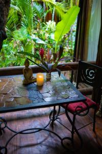 a table with a candle and a potted plant on it at Ocho Artisan Bungalows in Tamarindo