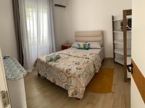 a small bedroom with a bed and a window at Sunny Side Up in Grand Baie