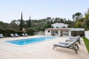 une piscine avec des chaises longues et une maison dans l'établissement Villa B, à Salernes
