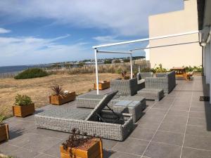 a patio with a bunch of chairs and tables at Superbe Villa Face à L'Océan in Plouhinec