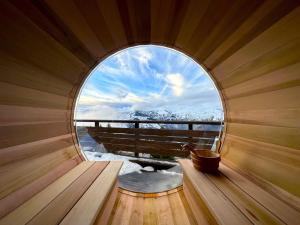 a round window in a wooden sauna with a view at La Cachette, Friendly Hotel & Spa in Arc 1600